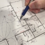 Hands holding pen adjusting custom floorplans